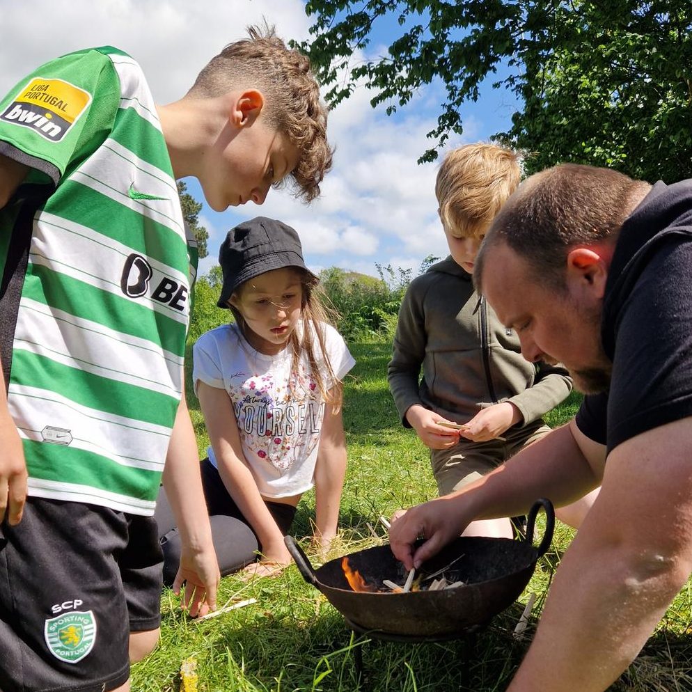 Bushcraft Skills and Fire-Making Activities for Young People | ROAM CIC Young people learning bushcraft skills and building small campfires outdoors.